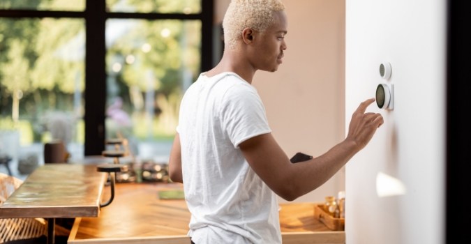 Man changing the temperature on his thermostat